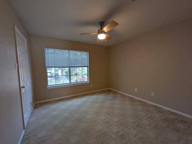 spare room with ceiling fan and light carpet