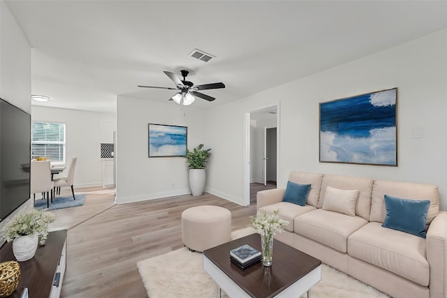 living room with ceiling fan and light wood-type flooring