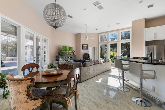 dining room featuring french doors and ceiling fan with notable chandelier