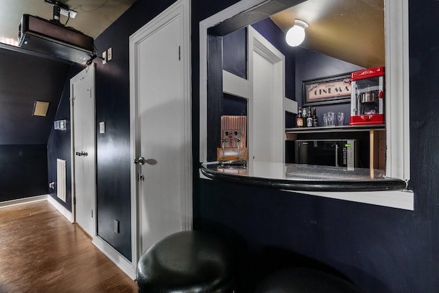 bar with hardwood / wood-style flooring and lofted ceiling