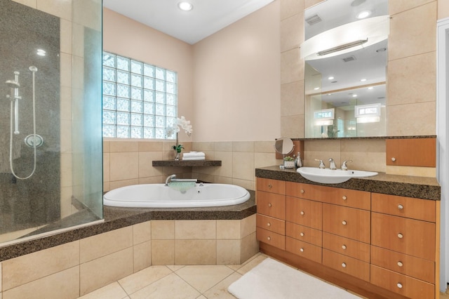 bathroom with tile patterned floors, separate shower and tub, vanity, and tile walls