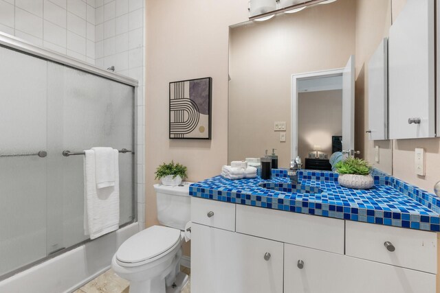 full bathroom with shower / bath combination with glass door, vanity, and toilet