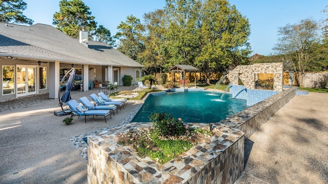 view of swimming pool with a patio, pool water feature, and ceiling fan