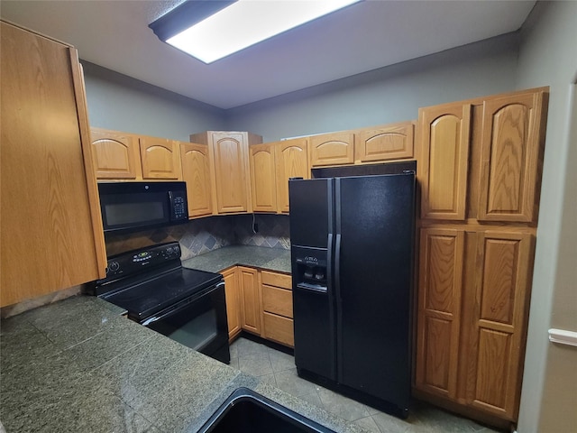 kitchen with black appliances, backsplash, and light brown cabinetry