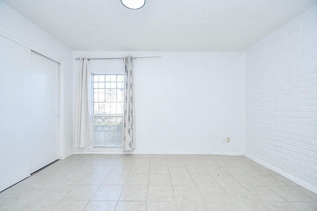 unfurnished room with brick wall