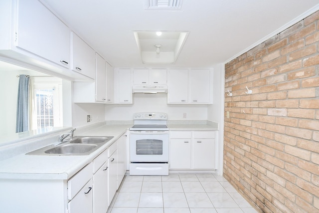 kitchen featuring white electric range, sink, light tile patterned floors, white cabinetry, and brick wall