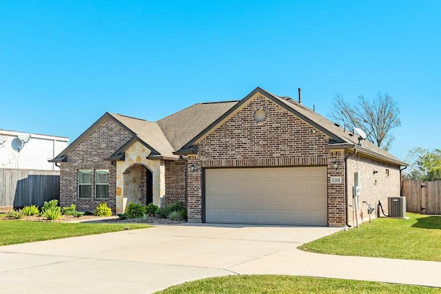 view of front of house with a front lawn, a garage, and central AC