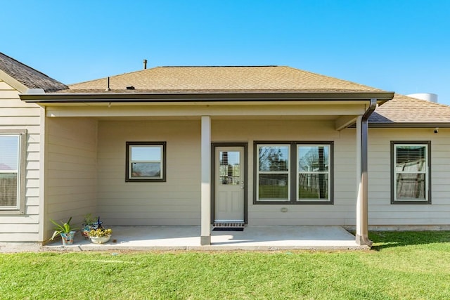 rear view of property featuring a lawn and a patio