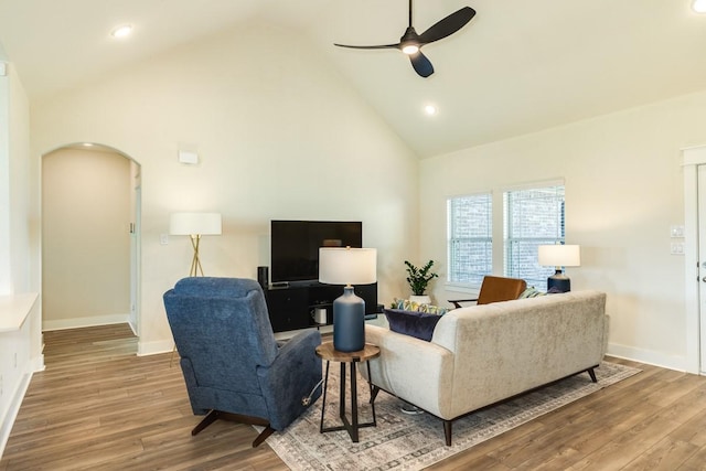 living room featuring ceiling fan, high vaulted ceiling, and wood-type flooring