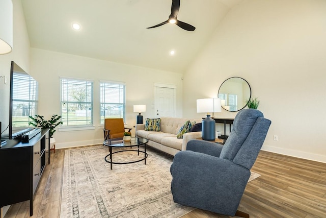 living room with hardwood / wood-style flooring, high vaulted ceiling, and ceiling fan