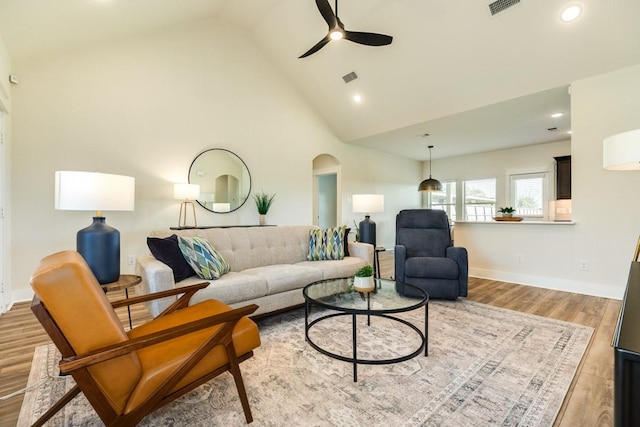 living room featuring ceiling fan, light hardwood / wood-style floors, and high vaulted ceiling