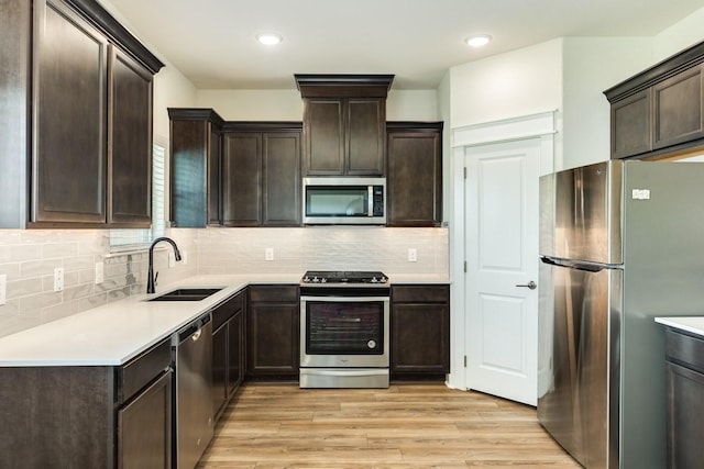 kitchen with sink, tasteful backsplash, light hardwood / wood-style floors, dark brown cabinetry, and stainless steel appliances