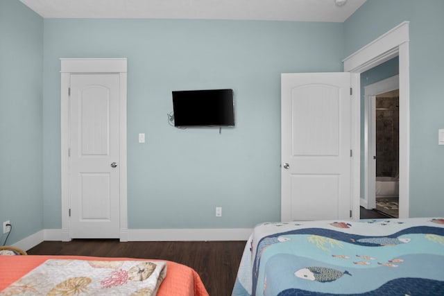 bedroom with connected bathroom and dark hardwood / wood-style flooring