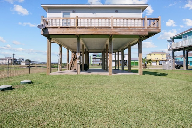 back of house featuring a lawn and a wooden deck