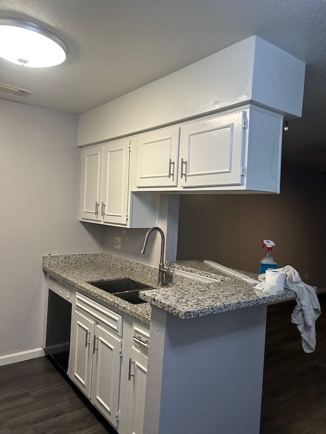 kitchen featuring dishwasher, light stone counters, sink, and white cabinets