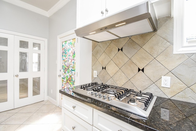 kitchen featuring dark stone counters, white cabinets, crown molding, tasteful backsplash, and stainless steel gas cooktop