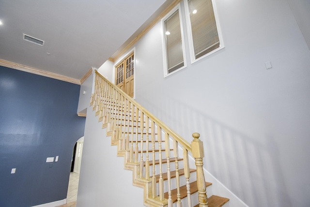 stairway featuring tile patterned floors and crown molding