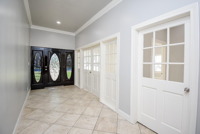 foyer entrance with light tile patterned floors and crown molding