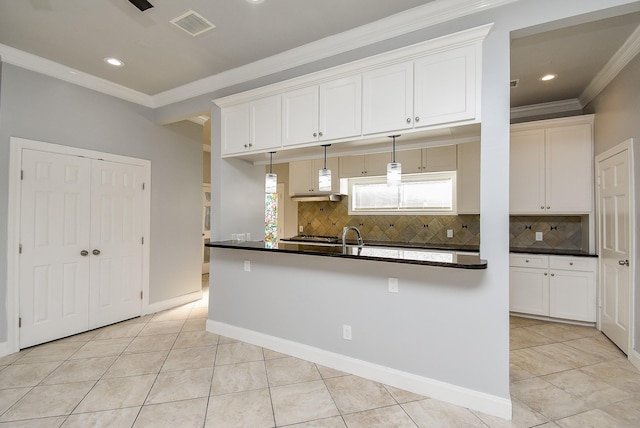 kitchen with pendant lighting, crown molding, light tile patterned floors, tasteful backsplash, and white cabinetry