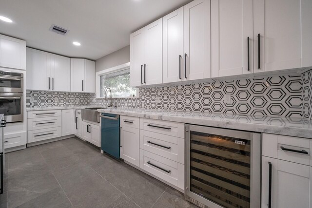 kitchen featuring decorative backsplash, stainless steel appliances, white cabinetry, and beverage cooler