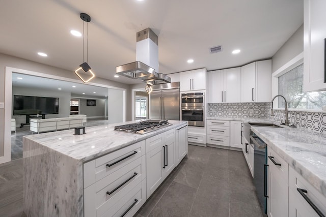 kitchen with light stone countertops, stainless steel appliances, white cabinets, and hanging light fixtures