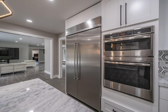 kitchen with white cabinetry, stainless steel appliances, and dark wood-type flooring