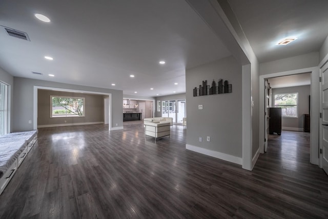 unfurnished living room featuring a fireplace and dark wood-type flooring