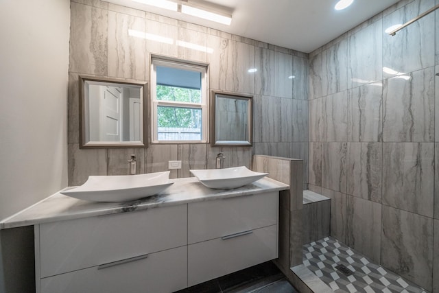 bathroom featuring vanity, walk in shower, and tile walls