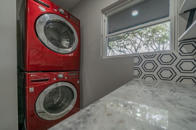 clothes washing area featuring stacked washing maching and dryer