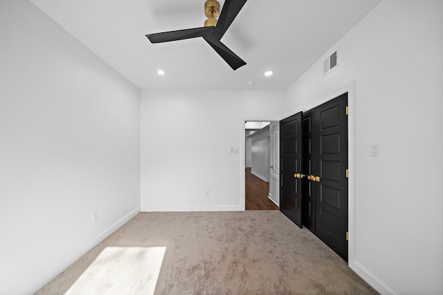 carpeted spare room featuring ceiling fan