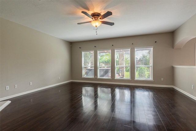 empty room with ceiling fan and dark wood-type flooring