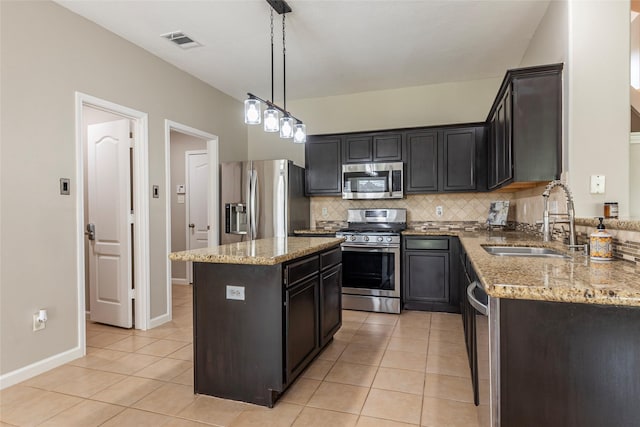 kitchen featuring sink, hanging light fixtures, light tile patterned floors, a kitchen island, and stainless steel appliances