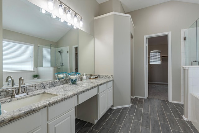 bathroom featuring vanity, lofted ceiling, and shower with separate bathtub