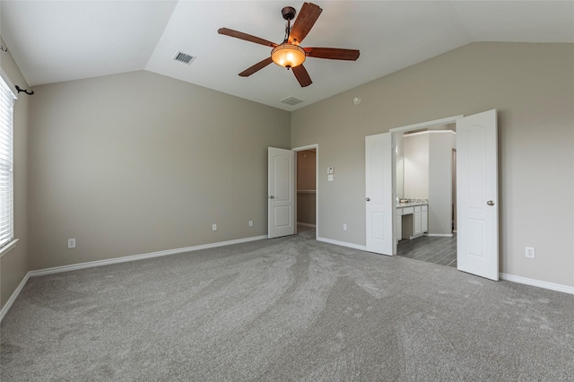 unfurnished bedroom with carpet, ceiling fan, lofted ceiling, and ensuite bathroom