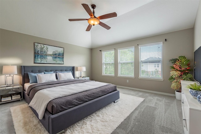 carpeted bedroom featuring multiple windows, ceiling fan, and lofted ceiling