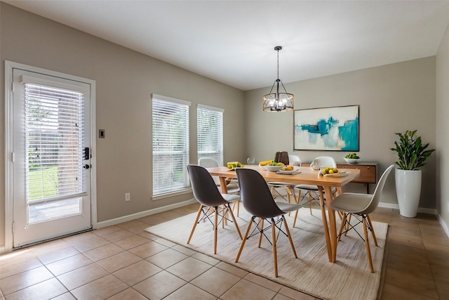 dining space featuring light tile patterned flooring and a notable chandelier