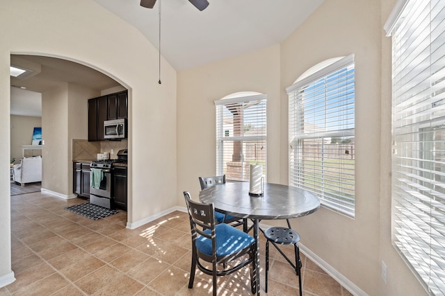 dining room featuring ceiling fan, light tile patterned floors, and lofted ceiling