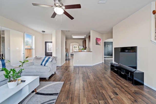 living room with dark hardwood / wood-style flooring and ceiling fan