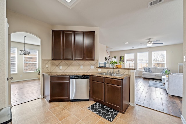 kitchen with light stone countertops, sink, stainless steel dishwasher, backsplash, and kitchen peninsula