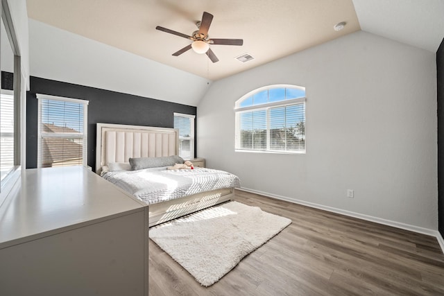 unfurnished bedroom with dark hardwood / wood-style flooring, vaulted ceiling, and ceiling fan