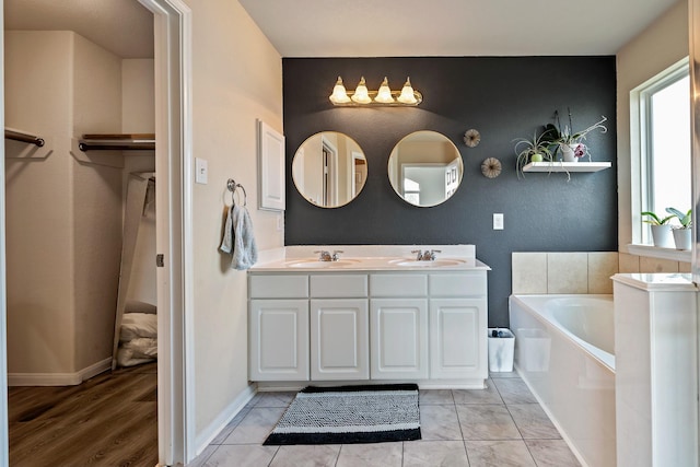 bathroom featuring tile patterned floors, a bathtub, and vanity