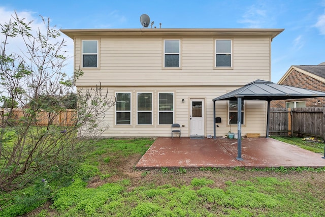 rear view of property with a gazebo, a patio area, and a lawn