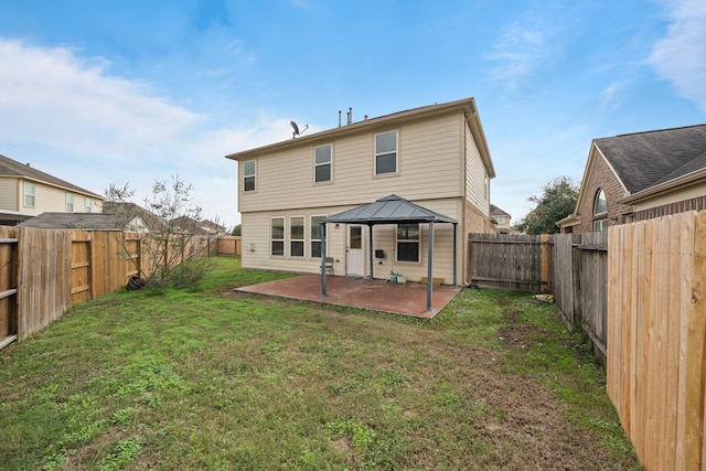 rear view of house featuring a gazebo, a patio area, and a lawn