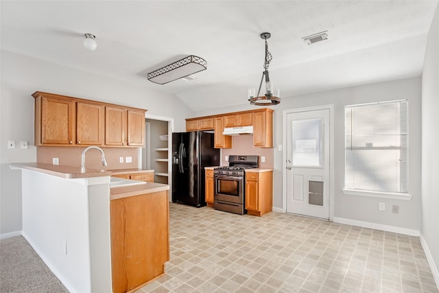 kitchen featuring gas range, sink, black refrigerator with ice dispenser, kitchen peninsula, and pendant lighting