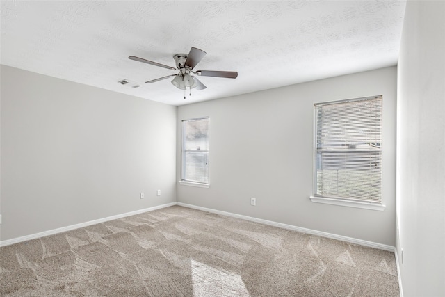 carpeted spare room with ceiling fan and a textured ceiling