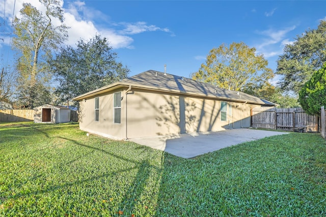 rear view of property with a patio area, a yard, and a storage shed