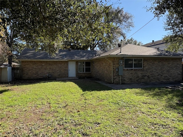 rear view of house with a yard and a storage unit