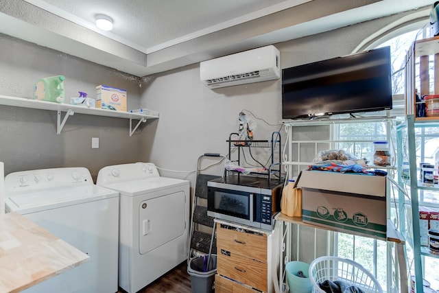 washroom with dark hardwood / wood-style flooring, a textured ceiling, separate washer and dryer, and a wall unit AC