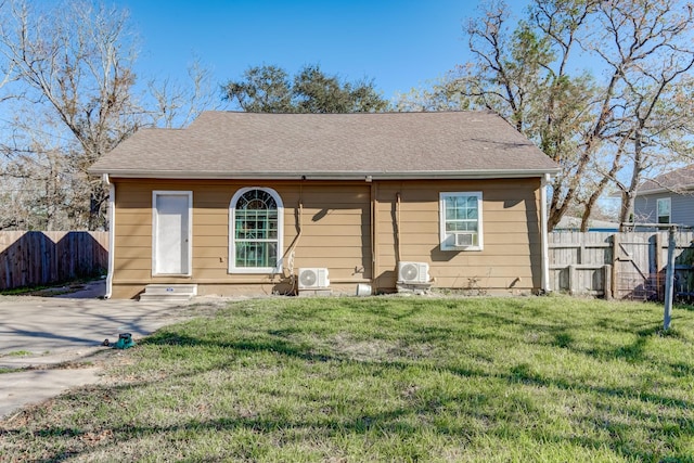 back of house featuring a lawn, ac unit, and cooling unit