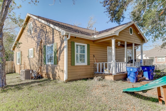 back of property featuring cooling unit and a lawn